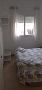 a bedroom with a bed with a quilt on it at La Casita del pescador in Cabo de Palos