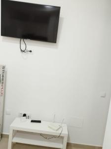 a white desk with a tv on a white wall at La Casita del pescador in Cabo de Palos