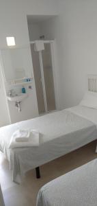 a white room with a bed and a sink at La Casita del pescador in Cabo de Palos +11 photos