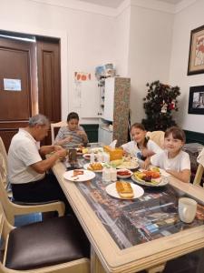 un grupo de personas sentadas en una mesa comiendo comida en The Castle Stay en Chuncheon