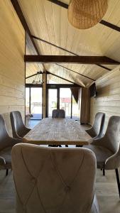 a large wooden table with chairs in a room at Гостинично-банный комплекс PARADISE in Shchūchīnsk