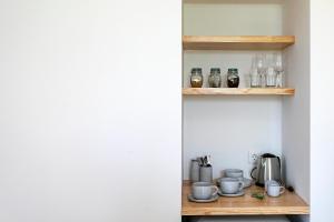 a room with a shelf with cups and glasses at Solar Branco Eco Estate in Ponta Delgada