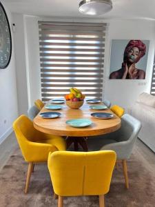 stół jadalny z krzesłami i miską owoców na nim w obiekcie Acogedora casa en Madrid con piscina privada, jacuzzy y garaje w Madrycie