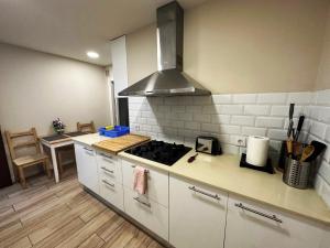 uma cozinha com armários brancos e um forno com placa de fogão em Rooms Sepulveda em Barcelona