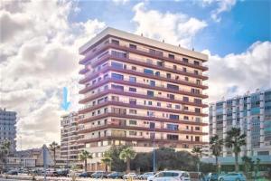 a tall building with cars parked in front of it at Nice room-Terrace- Private toilete-Closer Sport Pier-Optical Fiber 1 GB in Las Palmas de Gran Canaria