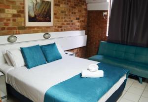 a bedroom with a large bed and a couch at Marco Polo Motor Inn Sydney in Sydney