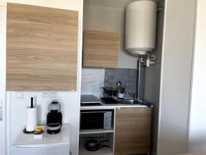 a small kitchen with a stove and a microwave at Studio Horizon Bleu, vue mer in Calais