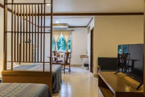 1 Schlafzimmer mit 2 Betten, einem Tisch und einem Schreibtisch in der Unterkunft Howard Square Boutique Hotel in Bangkok