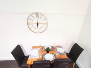 una mesa con sillas y un reloj en la pared en Cozy Apartment en Cambois