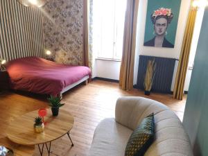 a living room with a couch and a table at De Vert et d'Or - proche gare - parking - jardin in Saint-Brieuc