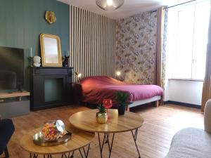 a living room with a bed and a table at De Vert et d'Or - proche gare - parking - jardin in Saint-Brieuc