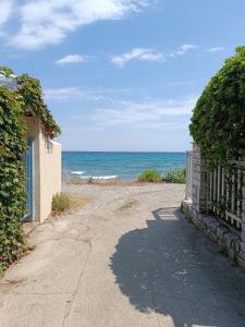a dirt road leading to the ocean with a fence at Niki Apartments Beach Loft in Platamonas