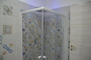 y baño con ducha y puerta de cristal. en Anna's B&B en Pozzuoli