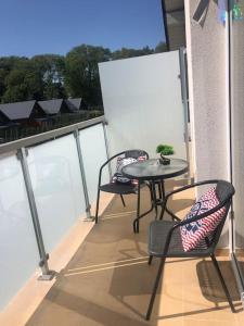 un balcón con 2 sillas y una mesa en el balcón en Nowy tani apartament, en Darłowo