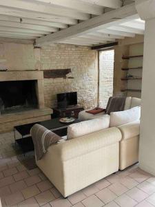- un salon avec un canapé et une cheminée dans l'établissement Maison typique en pierre de Caen - 4 voyageurs, à Louvigny