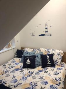 a bedroom with a bed with a lighthouse on the wall at Nowy tani apartament in Darłowo