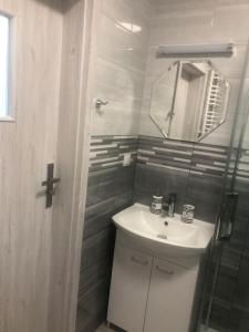 a bathroom with a sink and a mirror at Nowy tani apartament in Darłowo