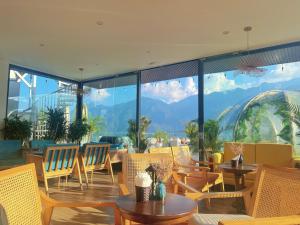 a restaurant with tables and chairs and a view of mountains at Sapa Relax Hotel & Spa in Sapa