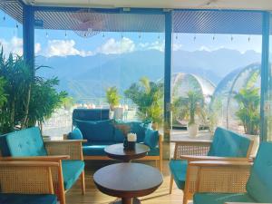 薩帕的住宿－Sapa Relax Hotel & Spa，客房设有桌椅和大窗户。