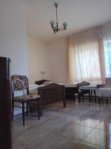 ein Wohnzimmer mit einem Bett, einem Sofa und Stühlen in der Unterkunft PENSIUNEA BIO in Coltău