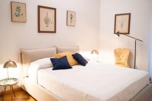 una camera da letto con un letto bianco con cuscini blu di Villa Terme di Caracalla with private Swimming Pool a Roma