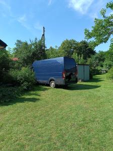 a blue van parked in the grass in a yard at Parkowe Ranczo in Poraj