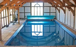 una gran piscina en un edificio con en The Shippon Barn with Hot Tub and Private Pool en Wirral