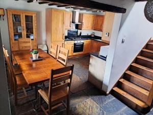 uma cozinha e sala de jantar com uma mesa de madeira em The Shippon Barn with Hot Tub and Private Pool em Wirral