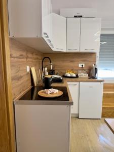 a kitchen with white cabinets and a plate on a counter at Holiday Home Korda in Čapljina