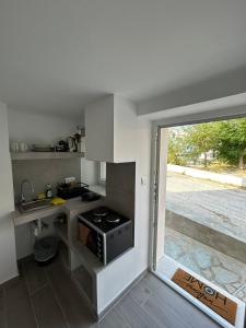 a kitchen with a stove and a sink and a window at DK Square in Andros