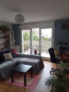 a living room with a couch and a table at Chambre pour deux personnes dans un logement partagé Two persons room in a shared apartment in Alfortville