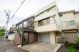 an apartment building with a parking lot in front of it at Ota Building - Vacation STAY 13991 in Otaru