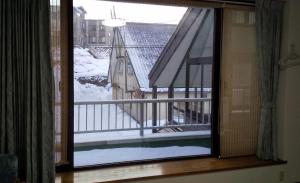 een raam met uitzicht op een balkon met sneeuw bij Ota Building - Vacation STAY 14022 in Otaru
