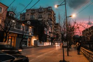 a city street at night with cars and buildings at Vila Pllaha in Korçë