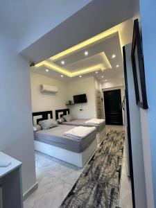 ein großes Schlafzimmer mit 2 Betten und einem TV in der Unterkunft ستديو مفروش - غرفة فندقيه - للايجار Studios - Room in Madinat as-Sadis min Uktubar