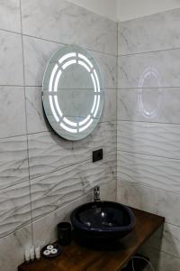 uma casa de banho com um lavatório preto e um espelho em Vila Pllaha em Korçë