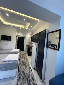 um pequeno quarto com 2 camas e um frigorífico em ستديو مفروش - غرفة فندقيه - للايجار Studios - Room em Cidade 6 de Outubro