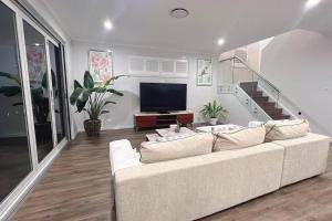 Dunmore7 Aurora Ave Dunmore的客厅配有白色沙发和平面电视。