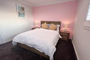 een slaapkamer met een groot bed met 2 nachtkastjes bij 7 Aurora Ave Dunmore in Dunmore