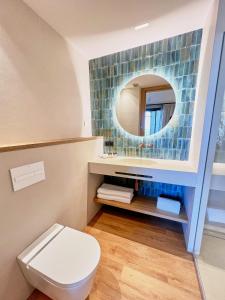 a bathroom with a toilet and a mirror at Casa Indiana Hotel Boutique in Blanes
