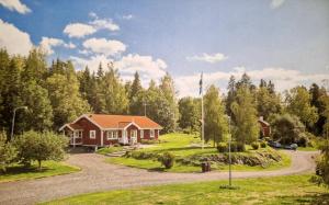 uma casa com uma bandeira em frente a uma floresta em Lantlig villa utanför Uppsala em Alunda