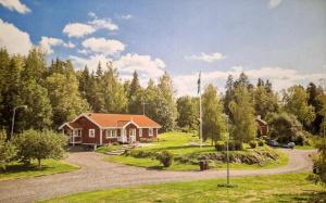 a house with a flag in front of a forest at Lantlig villa utanför Uppsala in Alunda