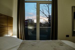 a bedroom with a bed and a window with a view at Vila Pllaha in Korçë