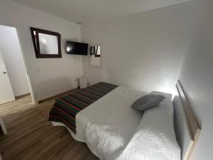 a bedroom with a bed and a flat screen tv at Loft Fontanales in Agua de Fontanales