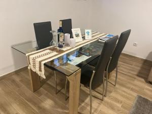 a glass table with black chairs and bottles on it at Loft Fontanales in Agua de Fontanales