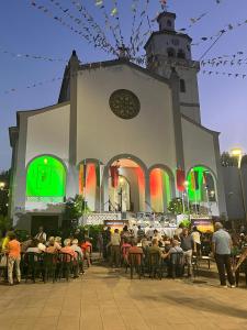 um grupo de pessoas sentadas em frente a uma igreja em Loft Fontanales em Agua de Fontanales