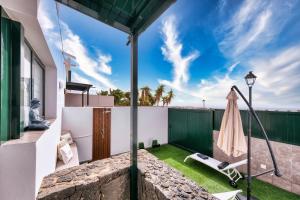 a patio with a hammock and a fence at Casa Costa Esmeralda Plus-Pool and Relax in Costa Teguise