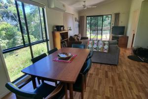 a living room with a wooden table and chairs at Bellthorpe Stays in Maleny