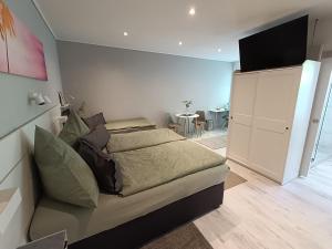 ein Schlafzimmer mit einem Bett und ein Wohnzimmer mit einem Tisch in der Unterkunft Pension Mojito Senftenberg in Senftenberg