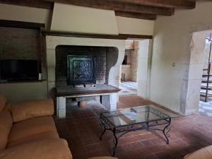 ein Wohnzimmer mit einem Sofa und einem Kamin in der Unterkunft Clos du château 